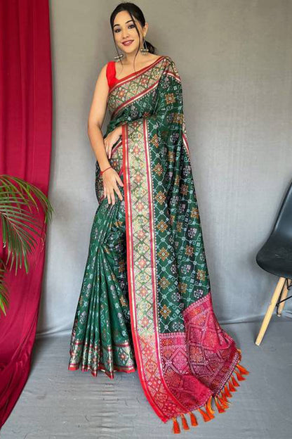 Jazzy Dark Green Patola Silk Saree with Cynosure Blouse Piece